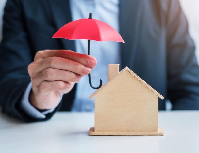 main-homme-affaires-tenant-couverture-parapluie-rouge-modele-maison-bois-assurance-immobiliere-concepts-propriete
